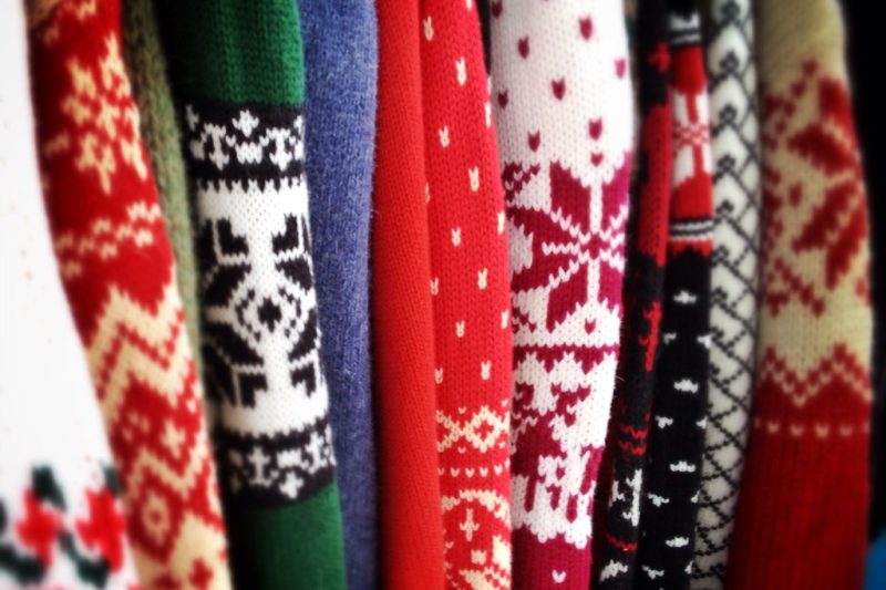 A row of warm Nordic-pattern knit sweaters hanging side by side