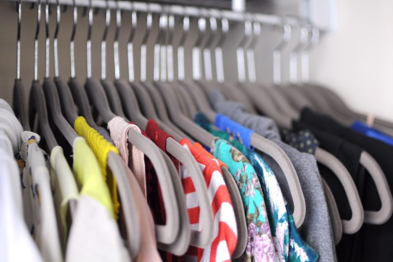 Clothes neatly hung on matching hangers in an organised wardrobe